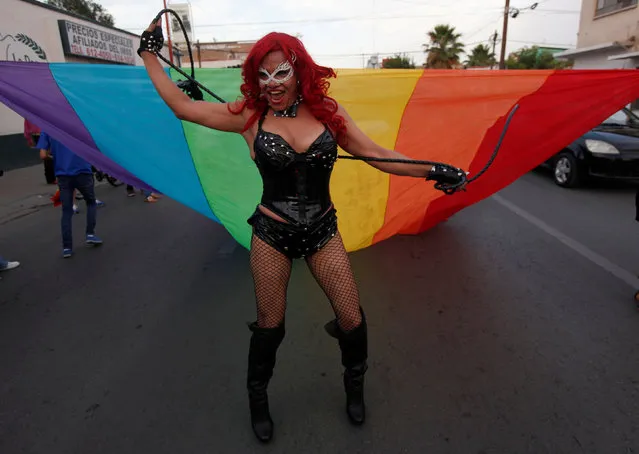 A participant perfoms in front of a rainbow flag during an annual Gay Pride Parade along the streets of Ciudad Juarez, Mexico June 19, 2016. (Photo by Jose Luis Gonzalez/Reuters)
