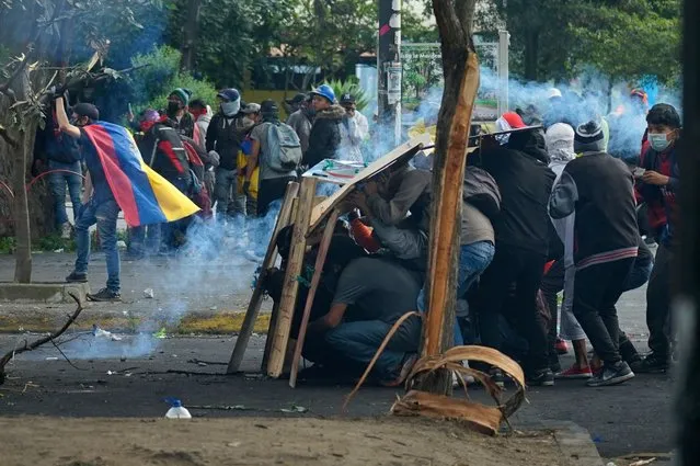 Demonstrators clash with the police in the surroundings of the House of Ecuadorean Culture in Quito, on June 22, 2022, on the tenth consecutive day of indigenous-led protests against the government. Ecuador on Wednesday refused to end its state of emergency and said 18 police officers are “missing” following an attack by indigenous protesters on a police station in the eastern Amazon region. Two people died in clashes with law enforcement during indigenous-led fuel price protests that have triggered regional states of emergency and a curfew in the capital Quito. (Photo by Veronica Lombeida/AFP Photo)