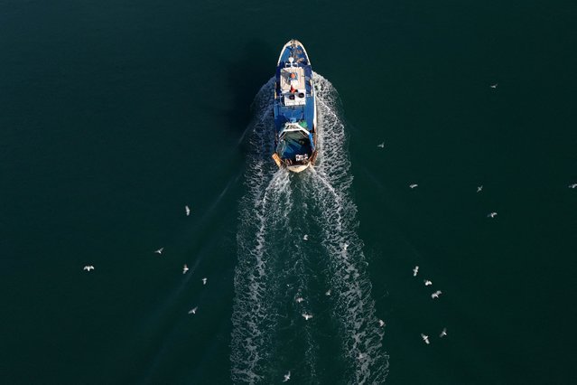 A drone view shows a boat arriving at the port near a reception camp for illegal migrants who are expected to be brought from Italy, in Shengjin, Albania, on October 15, 2024. (Photo by Florion Goga/Reuters)