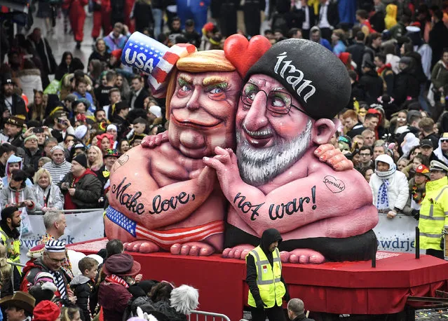 A carnival float depicts US President Donald Trump holding hands with Iran's President Hassan Rohani during the traditional carnival parade in Duesseldorf, Germany, on Monday, February 24, 2020. (Photo by Martin Meissner/AP Photo)