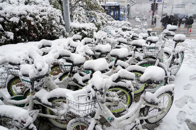 Snow-covered bicycles are parked near a subway station in Seoul, South Korea, Wednesday, November 27, 2024. (Photo by Ahn Young-joon/AP Photo)