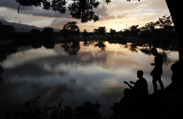 Men fish in a lake at Peace park in San Jose August 5, 2014. (Photo by Juan Carlos Ulate/Reuters)