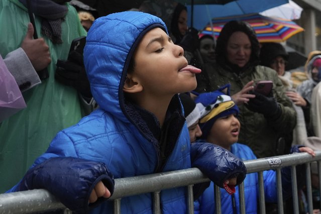 A young spectator catches raindrops with his tongue while watching the Macy's Thanksgiving Day Parade on Sixth Avenue, in New York, November 28, 2024. (Phoot by Julia Demaree Nikhinson/AP Photo)