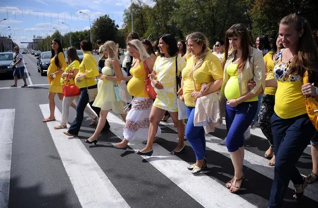 Pregnant women cross a road as they parade in central Minsk, Belarus on August 30, 2015. (Photo by Sergei Gapon/AFP Photo)