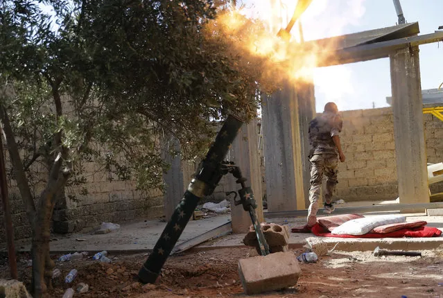 In this July 27, 2017 file photo, a U.S.-backed Syrian Democratic Forces fighter, runs as he fires mortars at Islamic State group militant, in Raqqa, northeast Syria. The Syrian Democratic Forces said in a statement Wednesday, September 20, 2017, that the battle for the Islamic State group's de-facto capital, Raqqa, has reached its “final stages” with the opening of a new front. (Photo by Hussein Malla/AP Photo)