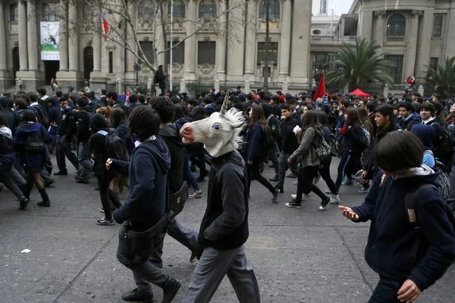 A high school student wears a mask as they attend a demonstration against the government to demand changes in the education system in Santiago, August 27, 2014. Chilean students have demanded changes and an end to profiteering in the education system. (Photo by Ivan Alvarado/Reuters)