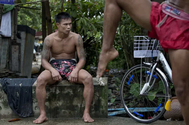 In this Tuesday, July 14, 2015, photo, a member of the White New Blood lethwei fighters club, a Myanmar traditional martial-arts club which practices a rough form of kickboxing, sits during a practice session in their gym on a street in Oakalarpa, north of Yangon, Myanmar. (Photo by Gemunu Amarasinghe/AP Photo)