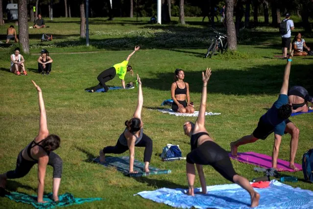 People exercise in a park in Barcelona, Spain, Wednesday, May 6, 2020. Spain has implemented time slots for different groups like for sport and exercise, for elders and for children, to control release of the population from lockdown while controlling the spread of the coronavirus with over 25,600 deaths from COVID-19. Spain's government has extended the country's current state of emergency for another 15 days. (Photo by Emilio Morenatti/AP Photo)