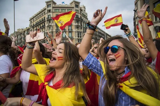 Demonstrators hold Spanish and Catalonian flags as they take part in a rally to mark Spain's National Day in Barcelona, Spain on October 12, 2017. The rally held under motto “Catalonia yes, Spain too” was against Catalonian indepence. (Photo by Alessandro Serrano'/Rex Features/Shutterstock)