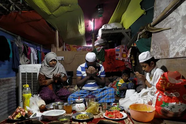 Rohingya refugees Taslima, 35, Zaffar Hussain, 39, and Shahid Hussain, 10, pray as Rizwan, 3, looks on before eating their Iftar meal at their house in a camp, during the fasting month of Ramadan and amid the outbreak of the coronavirus disease (COVID-19) in New Delhi, India April 30, 2020. (Photo by Anushree Fadnavis/Reuters)