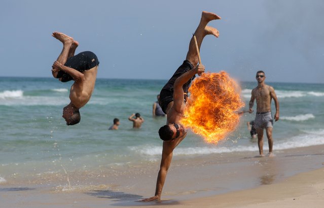 A Palestinian man performs fire breathing on the beach in Gaza City on 02 September 2022. (Photo by Majdi Fathi/NurPhoto/Rex Features/Shutterstock)