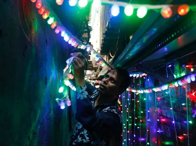 A man puts lights in an alley the eve of the Hindu festival of Diwali in a slum in Mumbai, October 18, 2017. (Photo by Danish Siddiqui/Reuters)