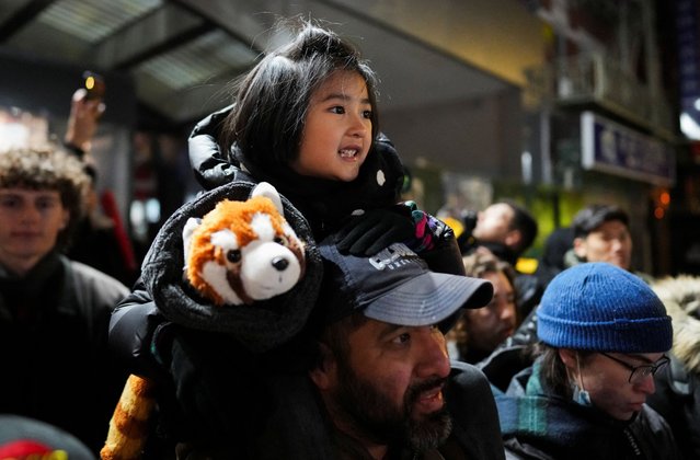 People watch dancers wearing lion costumes perform during a midnight Lunar New Year celebration, marking the Year of the Snake, in New York City's Chinatown section, in Manhattan, on January 28, 2025. (Photo by Adam Gray/Reuters)