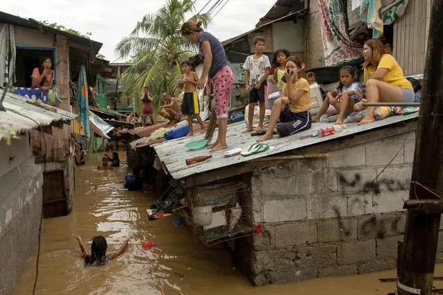 Residents wait on the roof of their homes for the flooding to subside after Super Typhoon Noru, in San Miguel, Bulacan province, Philippines on September 26, 2022. (Photo by Eloisa Lopez/Reuters)