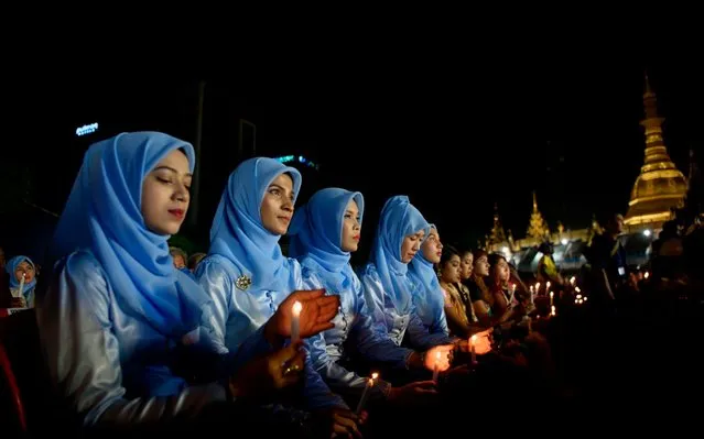 Muslim girls hold candles as they take part in an Interreligious Gathering of Prayer for Peace ceremony in Yangon on October 31, 2017. The gathering is to show how unity in a country seared by ethnically- charged violence against the Muslim Rohingya on its western border. Buddhist monks, Christian nuns, Hindus and Muslims were among those who joined the gathering in a display of support for government leader Aung San Suu Kyi' s handling of the crisis in Rakhine. (Photo by Ye Aung Thu/AFP Photo)