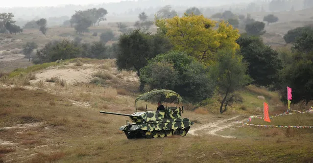 A friend of Li Guojun drives a homemade tank-shaped vehicle, in Kangping county, Shenyang, Liaoning province, September 26, 2014. Li, a farmer who is a fan of tanks, spent six months with help from his friends, to construct the vehicle which weighs 2.5 tons, according to local media. (Photo by Reuters/Stringer)