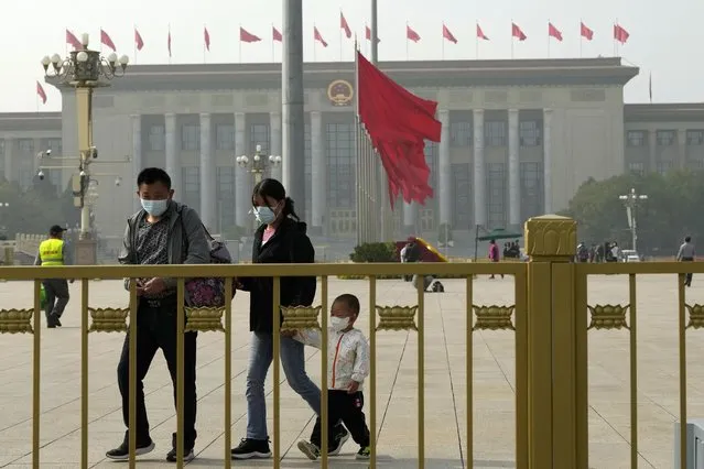 Visitors wear masks as they walk on Tiananmen Square across from the Great Hall of the People where the upcoming 20th Communist Party Congress will be held in Beijing, Friday, October 14, 2022. China's ruling Communist Party is holding its twice-a-decade national congress starting Sunday, Oct. 16, 2022. That's where President Xi Jinping is expected to receive a third five-year term as the uncontested head of the party, government and military of the world's second-largest economy. (AP Photo/Ng Han Guan)