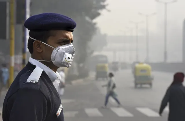 People and traffic police wearing a mask during the implementation of odd-even vehicle formula at ITO crossing on January 4, 2016 in New Delhi, India. Contrary to apprehensions, Delhi's odd-even vehicle scheme aimed at battling pollution did not lead to the feared problems on Monday, the first full working day of the New Year. The 15-day odd-even scheme started on January 1 and aims to put odd numbered vehicles on the roads on odd dates and even numbered vehicles on even dates. (Photo by Arvind Yadav/Hindustan Times via Getty Images)