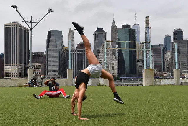 Regina Sarrubbo (25, Long Island resident, personal fitness trainer) takes advantage of the Brooklyn Bridge Park in NYC waterfront by working on her flexibility moves on June 18, 2020. (Photo by Paul Martinka/The New York Post)