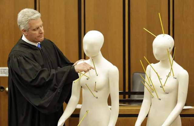 County Common Pleas Court Judge John O'Donnell points to mannequins marked with the gunshot wounds that the two motorists suffered Saturday, May 23, 2015, in Cleveland. (Photo by Tony Dejak/AP Photo)