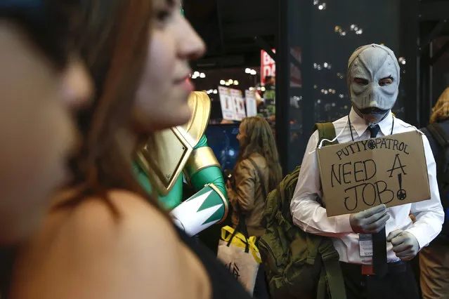 A costumed attendee holds a sign at New York's Comic-Con convention, October 9, 2014. (Photo by Shannon Stapleton/Reuters)