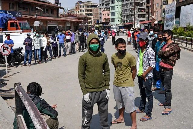 People stand in queues as they wait to be tested for a coronavirus test at Kalimati vegetable market during a government-imposed nationwide lockdown as a preventive measure against the spread of the COVID-19 coronavirus, in Kathmandu on May 14, 2020. (Photo by Prakash Mathema/AFP Photo)
