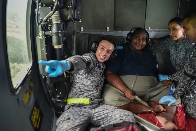 Didier Silva (C), 22, smiles on a helicopter on December 2, 2017, in Mosquera, department of Narino, Colombia, while he is transferred to Cali. (Photo by Luis Robayo/AFP Photo)