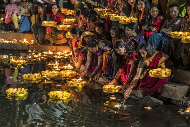 Hindu women light oil lamps at the Banganga pond as they celebrate Dev Diwali festival in Mumbai, India, Monday, November 7, 2022. (Photo by Rafiq Maqbool/AP Photo)