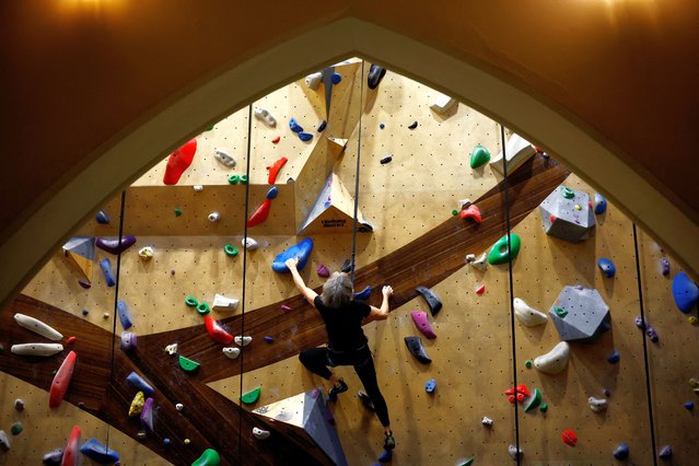 A woman practices climbing in a former 19th century chapel at the Climbing District place in Paris, France on January 22, 2024. (Photo by Sarah Meyssonnier/Reuters)