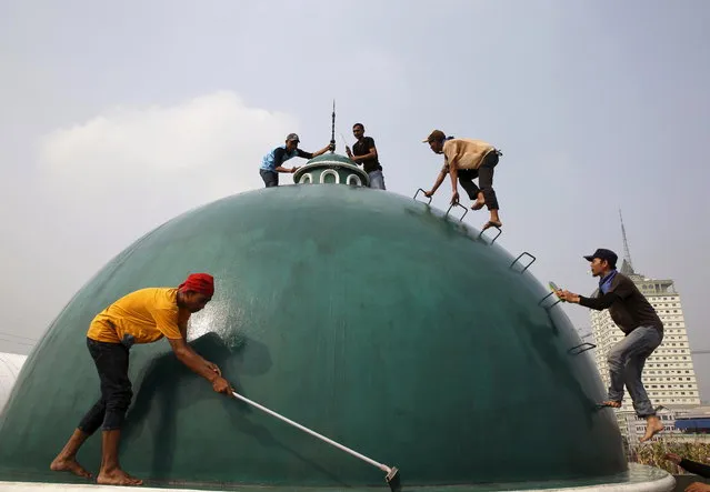 Youths clean a dome of a mosque ahead of the upcoming holy fasting month of Ramadan in Jakarta, June 15, 2015. (Photo by Reuters/Beawiharta)
