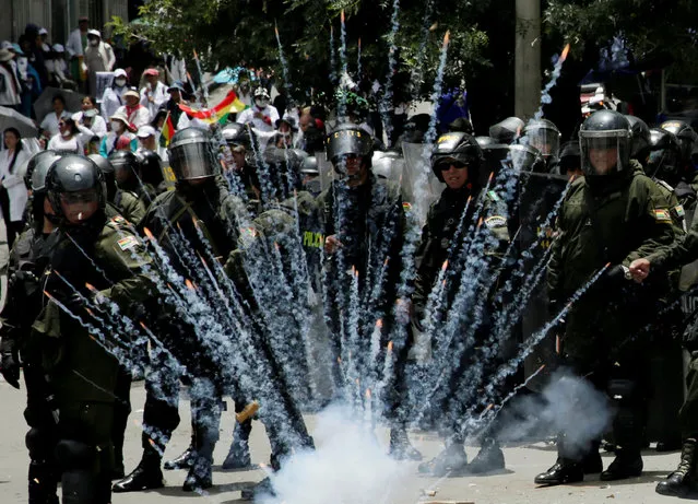 A firecracker explodes next to riot police officers during a protest rally against Bolivia's government new health care policies in La Paz, Bolivia December 27, 2017. (Photo by David Mercado/Reuters)