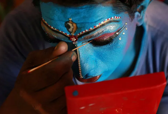 A man gets ready backstage before performing in the 34th Cochin Carnival which is held annually to welcome the start of the New Year at Fort Kochi in the southern state of Kerala, India, January 1, 2018. (Photo by Sivaram V/Reuters)
