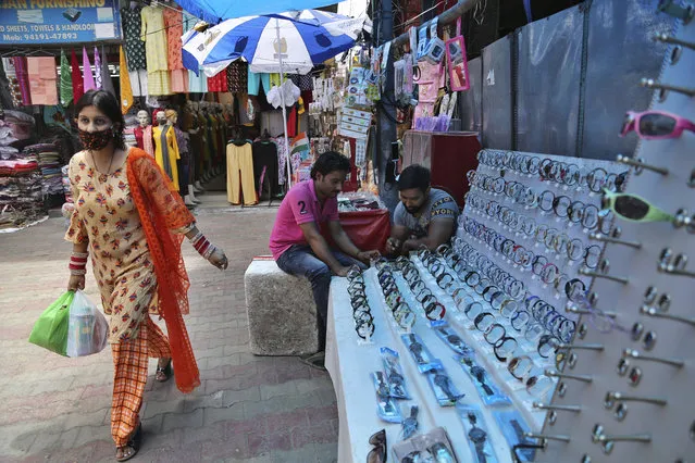 A woman wearing face mask as a precaution against the coronavirus walks at market in Jammu, India, Thursday, August 6, 2020. (Photo by Channi Anand/AP Photo)