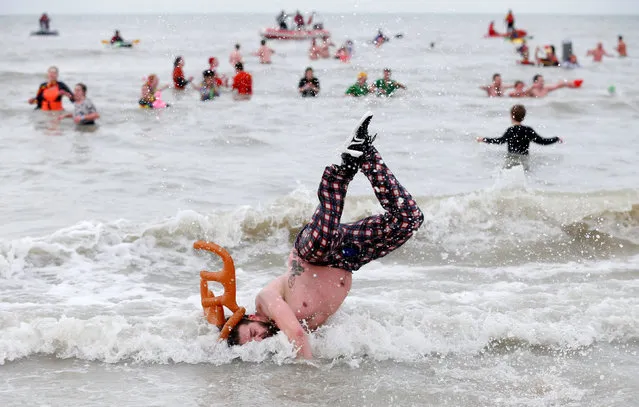 A participant jumps in the waters of the North Sea during the annual New Year's plunge event in Ostend, Belgium, January 6, 2018. (Photo by Francois Lenoir/Reuters)