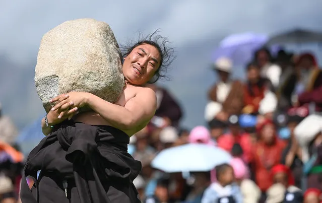 A participant competes during a stone-lifting competition at the Dangjiren horse racing festival in Damxung County, southwest China's Tibet Autonomous Region, August 11, 2020. (Photo by Xinhua News Agency/Rex Features/Shutterstock)