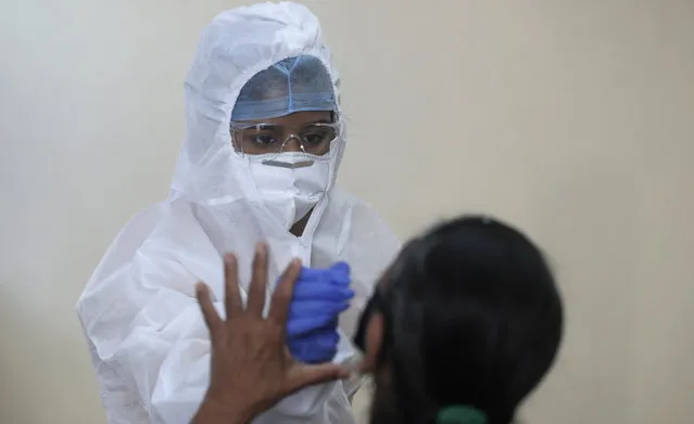 A health worker takes a nasal swab sample to test for COVID-19 in Mumbai, India, Saturday, September 12, 2020. India's coronavirus cases are now the second-highest in the world and only behind the United States. (Photo by Rafiq Maqbool/AP Photo)