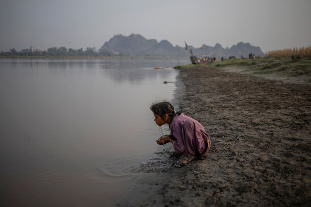 Asma, 11, a Saraiki girl, washes her face on the banks of the Chenab River in Chiniot, Pakistan, on June 17, 2025. (Photo by Adrees Latif/Reuters)