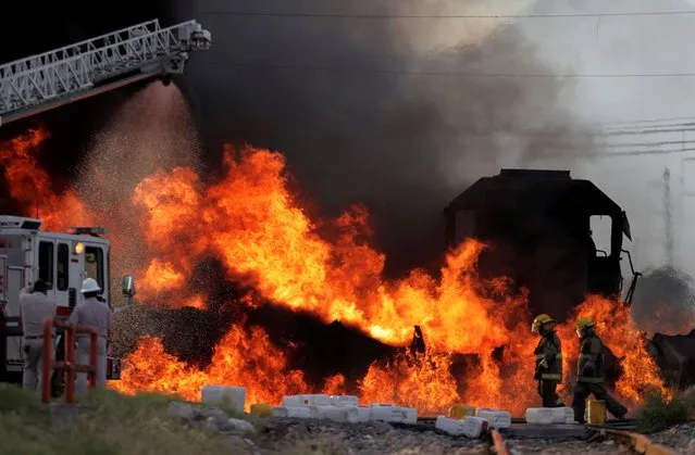 Firefighters try to extinguish flames of a burning tanker fuel truck, after a collision with a train of “Kansas City Southern de Mexico”, according to local media some workers were injured in San Nicolas de los Garza, on the outskirts of Monterrey, Mexico on August 8, 2020. (Photo by Daniel Becerril/Reuters)