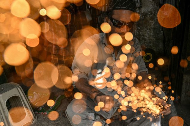 A blacksmith sharpens knives at a shop ahead of the Muslim festival of Eid al-Adha in Karachi on June 5, 2025. (Photo by Rizwan Tabassum/AFP Photo)