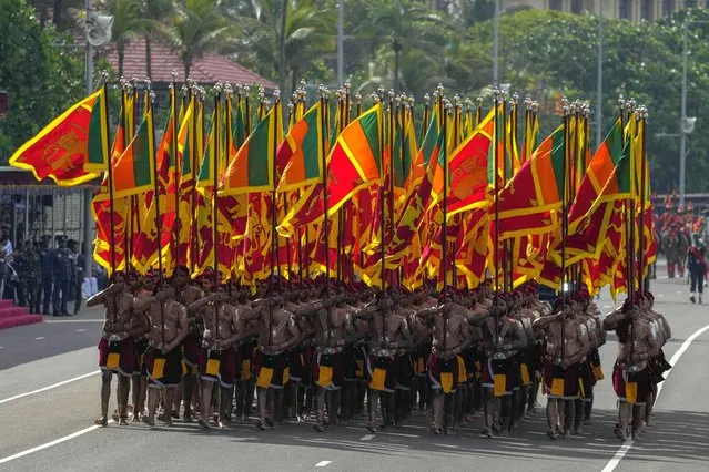 Sri Lankan army soldiers march carrying national flags during the 75th Independence Day ceremony in Colombo, Sri Lanka, Saturday, February 4, 2023. Sri Lanka marks the anniversary of independence from British colonial rule on Feb. 4 each year. (Photo by Eranga Jayawardena/AP Photo)