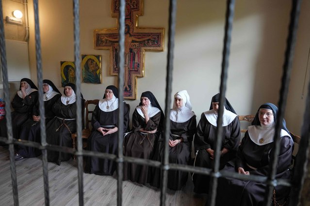 Eight former nuns of the order of the Poor Clares of Belorado, who were excomunicated by the Vatican after separating from the Catholic church, sit behind a grille which separates the nuns from visitors as they give a press conference following a trial hearing in their eviction lawsuit, at the Santa Clara Monastery in Beldorado, northern Spain, on July 29, 2025. (Photo by Cesar Manso/AFP Photo)