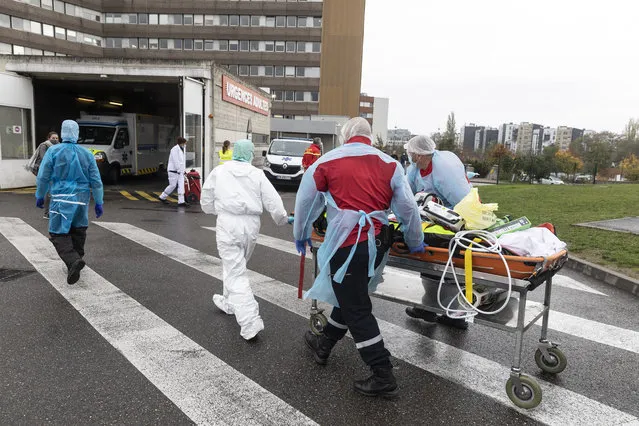 A patient infected with the COVID-19, coming from saturated hospitals in the Lyon region, is led to the Hautepierre hospital in Strasbourg, eastern France, Thursday, November 12, 2020. France has confirmed more virus infections in the pandemic than any other European country, and positive cases had been rising steadily since July. But over the past 10 days, the number of cases per 100,000 people has been dropping. (Photo by Jean-Francois Badias/AP Photo)