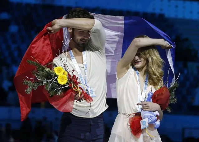 Bronze medallists Gabriella Papadakis and Guillaume Cizeron of France wave their national flag during an award ceremony after placing third in the Ice Dance final competition at the ISU Grand Prix of Figure Skating final in Barcelona December 13, 2014. (Photo by Gustau Nacarino/Reuters)