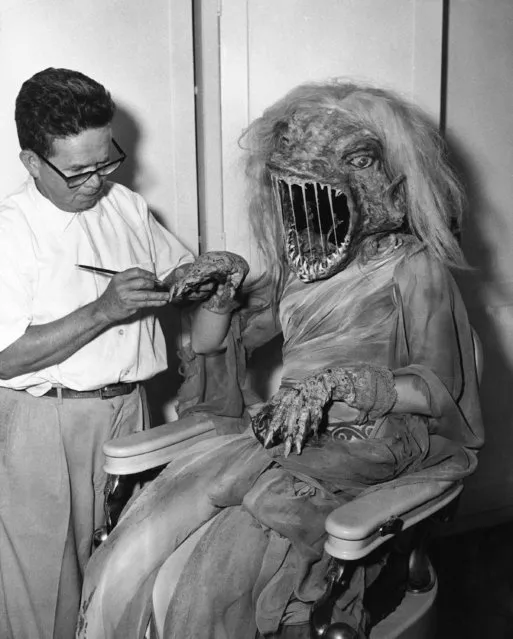 The witching hour for Karen Dolin arrives as makeup man Charles Gemora puts finishing touches on the rubber gauntlets she wears for her movie debut in Hollywood, February 7, 1961. Gemora designed the witch's horror mask which hides Karen's beauty, along with the others used in the film. (Photo by AP Photo)