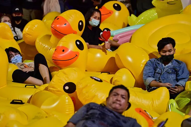 Pro-democracy protesters rest on large inflatable ducks during an anti-government rally at Lat Phrao intersection in Bangkok on December 2, 2020. (Photo by Lillian Suwanrumpha/AFP Photo)