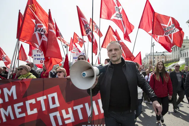 Russian opposition activist Sergey Udaltsov, foreground, leads a group of his supporters during a Communist rally to mark May Day in Moscow, Russia, May 1, 2018. More than 100,000 people came out on the streets on Moscow to march in the traditional May Day parade. The banner behind him reads “Communism instead of Putin”. (Photo by Alexander Zemlianichenko/AP Photo)