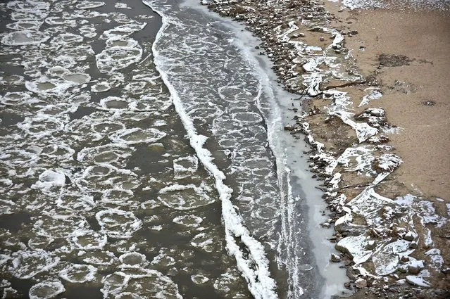 Pancake ice formed on the Vistula River, 31 December 2014 in Warsaw, Poland. Pancake ice consists of round pieces of ice that form when surface slush accumulates into floating pads. (Photo by Marcin Obara/EPA)