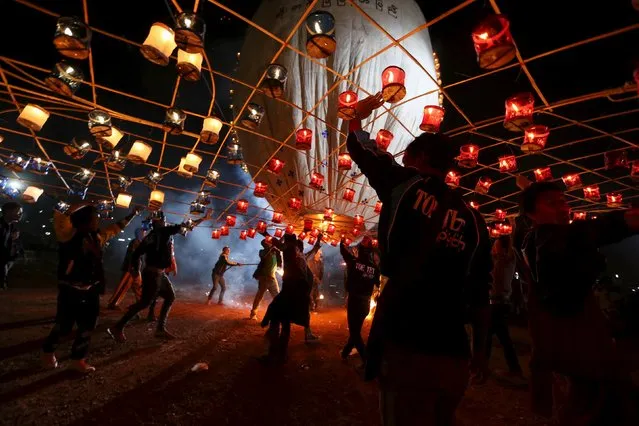 People light a traditional home-made paper balloon before releasing it into the sky during the annual Tazaungdaing festival in Taunggyi, Myanmar November 19, 2015. (Photo by Soe Zeya Tun/Reuters)