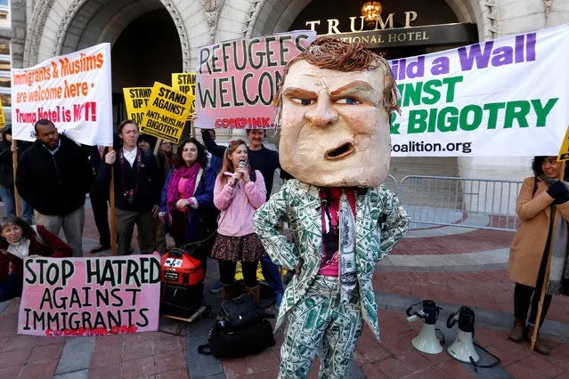A demonstrator dresses in a Trump costume as people gather to protest against Republican U.S. presidential nominee Donald Trump on the sidewalk, outside the grand opening of his new Trump International Hotel in Washington, U.S. October 26, 2016. (Photo by Jonathan Ernst/Reuters)
