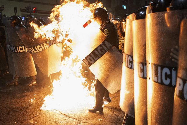 A riot police officer is hit by a Molotov cocktail thrown by protesters during an anti-government demonstration in Lima on September 21, 2025. (Photo by Ernesto Benavides/AFP Photo)